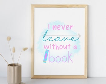 May include: A framed print with a watercolor background in shades of blue and pink. The text reads "I never leave without a book" with an arrow pointing to the right. A colorful book icon is below the text.