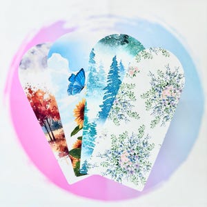 Peut inclure: Quatre impressions décoratives en forme de cœur avec des motifs à l'aquarelle. L'une représente des arbres d'automne, une autre un papillon bleu et un tournesol, une troisième une forêt enneigée et la dernière un motif floral.