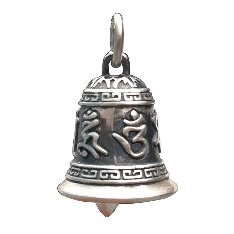 May include: Silver bell charm with intricate designs and the Om symbol. The bell has a loop at the top for hanging.