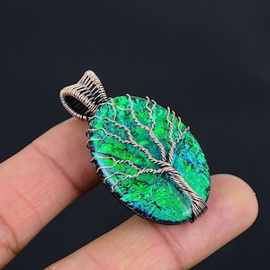 May include: A copper wire wrapped pendant featuring a green iridescent glass tree of life design.