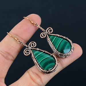 May include: A pair of copper wire wrapped earrings with green malachite stone drops.
