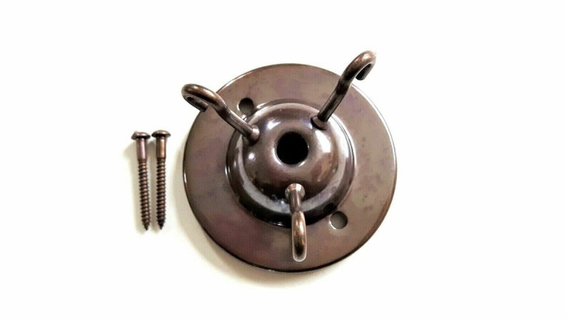 May include: A bronze ceiling fixture with three hooks and two screws. The fixture is designed to hold light fixtures or other hanging objects.
