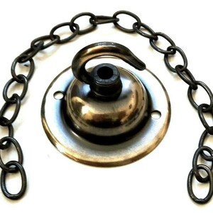May include: A silver ceiling hook with a chain attached. The hook is designed for hanging light fixtures.