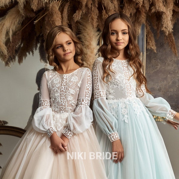 Flower girl dress with lace top and delicate tulle skirt. Long sleeves in the shape of "lanterns" decorated with lace with a floral pattern