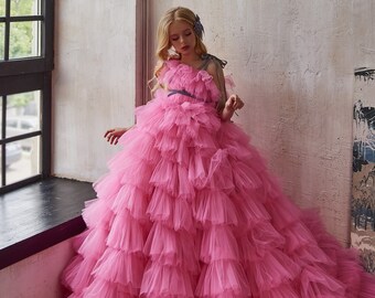 A fluffy, layered tulle dress in hot pink accented with a gray ribbon. Airy tulle dress for a flower girl. One-shoulder tulle ruffle dress