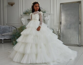 Shining tulle layered communion dress. Ivory children's fluffy dress created with a cascade of tulle layers and decorated with floral lace