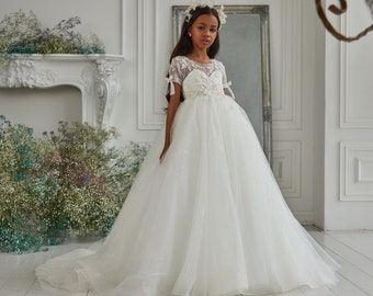 Shining tulle communion dress. Ivory children's delicate dress decorated with lace 3D flowers and embroidered with beads