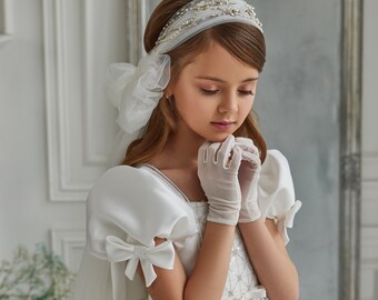 Satin communion dress. Ivory baby dress in royal satin embellished with geometric sequin embroidery on the bodice. Dress with a huge bow