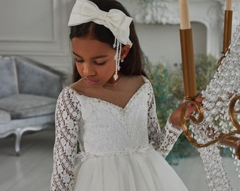 Tulle dress with long lace sleeves. Princess style dress with a neckline. White chic dress with a fluffy tulle skirt. White ball gown