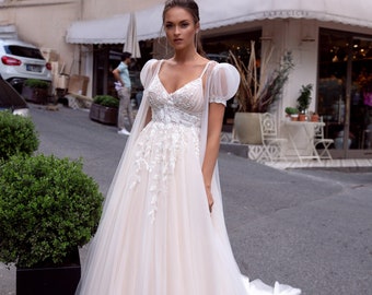 Cinderella style wedding dress. The dress with thin straps is created with delicate tulle and lace, embroidered with beads and stetlyars