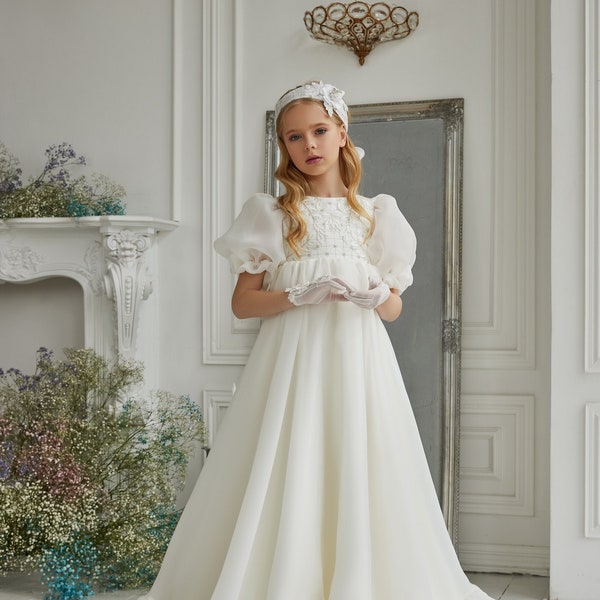 Kommunionkleid aus Chiffon. Elfenbeinfarbenes zartes Kinderkleid bestickt auf einem Korsett mit Pailletten und Perlen und verziert mit Spitzenblättern