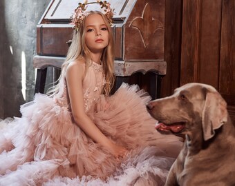 A fluffy tulle dress with a delicate floral pattern with 3D flowers and a tiered skirt created by tulle ruffles. American style bodice