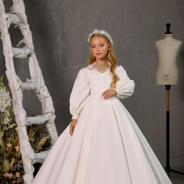 Satin white communion dress with long voluminous sleeves.  Dress for the first communion. White satin communion dress with lace