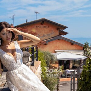 Gorgeous wedding dress made of expensive lace. The dress is decorated on the shoulders with removable tulle bows with glitter image 5