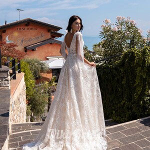 Gorgeous wedding dress made of expensive lace. The dress is decorated on the shoulders with removable tulle bows with glitter image 3