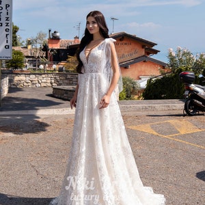 Gorgeous wedding dress made of expensive lace. The dress is decorated on the shoulders with removable tulle bows with glitter image 2