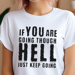 May include: White t-shirt with black text that reads "If you are going through hell, just keep going."