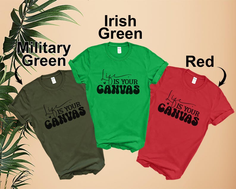 Pode incluir: Tr&ecirc;s camisetas em cores diferentes: verde militar, verde irland&ecirc;s e vermelho. Cada camiseta apresenta um gr&aacute;fico preto que diz "Life is your canvas".