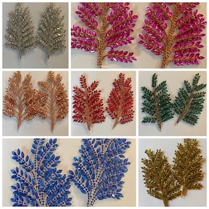 May include: Set of 10 rhinestone leaf branches in various colours, including silver, pink, red, green, blue, and gold. Each branch features a delicate, leafy design with sparkling rhinestones.
