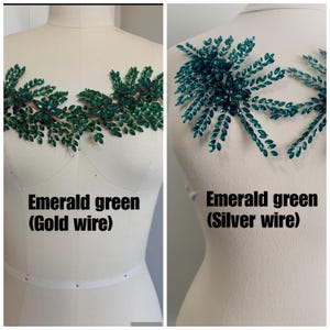 K&ouml;nnte beinhalten: Zwei Miederverzierungen mit smaragdgr&uuml;nen Kristallblattdesigns. Eines ist auf Golddraht, das andere auf Silberdraht. Der Text "Emerald green" wird unter jedem Design angezeigt.