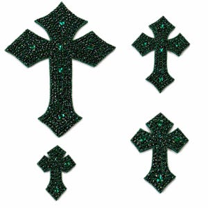 May include: Four dark green beaded cross patches of varying sizes are displayed against a white background. The crosses have a detailed design with small beads and larger green gems. The crosses are likely for embellishment or crafting.