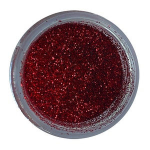 May include: A small jar filled with red glitter. The glitter is fine and sparkly.