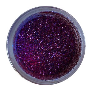 Puede incluir: Un pequeño frasco lleno de purpurina púrpura iridiscente.