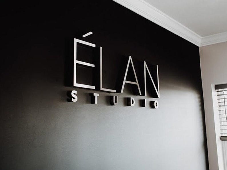 This photo shows the sign “ELAN STUDIO” on a dark wall, a business sign personalized specifically for the client.