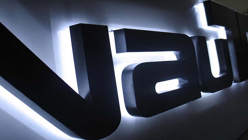 May include: Black 3D sign with white LED lights spelling out the word "VAU"