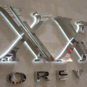May include: A silver metal sign with the words "XXI FOREVER" in large, bold letters. The letters are illuminated with white lights.