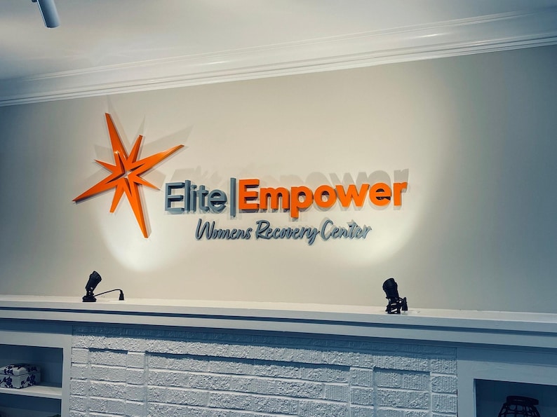 A metal interior sign is located on a light-colored office wall in a private workplace and powder coated in custom customer colors.