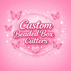 May include: Pink graphic with the text "Custom Beaded Box Cutters" in a cursive font. The image features pink butterflies, a heart, and sparkling starbursts on a pink background.