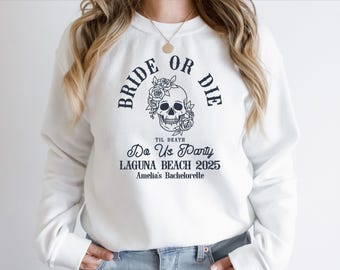 May include: White sweatshirt with a skull graphic and the words "BRIDE OR DIE" above it. Below the skull are the words "TIL DEATH Do Us Party LAGUNA BEACH 2025 Amelia's Bachelorette".