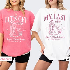 May include: Two white t-shirts with pink and white text and graphics. The left shirt says "Let's Get Rowdy" with a boot and a drink. The right shirt says "My Last Rodeo" with a boot and a drink. Both shirts say "Amy's Bachelorette Nashville, TN" and "Est. 2024".