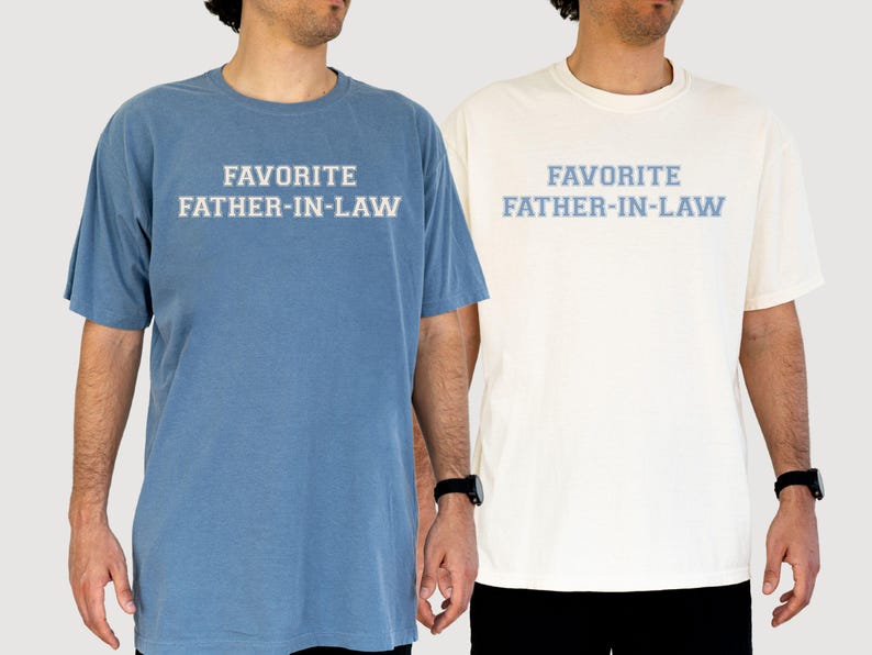 May include: Two short-sleeved t-shirts, one blue and one cream, each with the text "FAVORITE FATHER-IN-LAW" in light blue. The shirts are worn by individuals, suggesting casual wear. The text is centered on the chest.