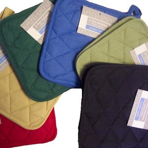 May include: A collection of quilted pot holders in various colors, including red, yellow, green, blue, and black. Each pot holder has a diamond pattern and a loop for hanging. The labels read "2 Pot Holders 100% Cotton CLASSIC HOME".