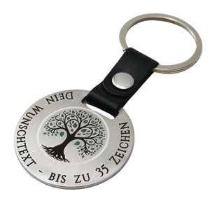 Könnte beinhalten: Ein runder Schlüsselanhänger aus Silber mit einem schwarzen Lederband und einem silbernen Ring. Der Schlüsselanhänger zeigt einen Baum mit grünen Blättern und den Text "DEIN WUNSCHTEXT - BIS ZU 35 ZEICHEN".