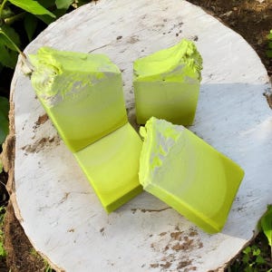 May include: Three bars of handmade soap in shades of green and white. The soap is in a swirl pattern and has a natural, earthy look.