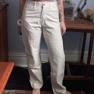 May include: A white ceramic mug with a black handle and the text "But First, Coffee" in a black, bold font. The mug is on a white surface.