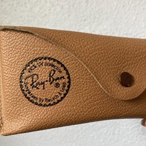 Op de afbeelding: Een handgemaakt houten bord met de tekst "Welcome to our home" in een handgeschreven stijl. Het bord is wit geschilderd met zwarte letters en een verweerde afwerking, perfect voor woondecoratie.