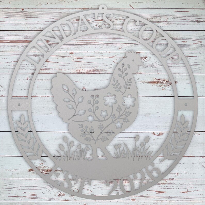 Decorative metal sign with a rooster design and 'Linda's Coop' text on a wooden background