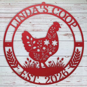 Red metal chicken coop sign with a chicken design and text on a wooden background