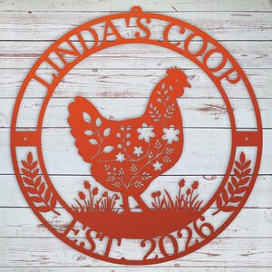 round metal chicken coop sign that's orange with name and date