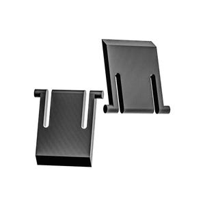 Puede incluir: Dos soportes metálicos negros con forma rectangular y un recorte en forma de U. Cada soporte tiene dos pequeñas protuberancias cilíndricas en los lados. Los soportes están colocados sobre un fondo blanco.