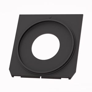 May include: A black, square-shaped camera accessory with a circular opening in the center. The accessory has a raised, circular rim around the opening and a smaller, circular indentation on the top surface. The edges are angled and have small cutouts.