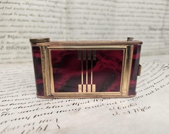 Cámara compacta vintage Art Déco de esmalte rojo, artículo de colección para tocador.