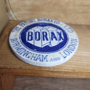 May include: A white ceramic lid with blue lettering that reads "The Patent Borax Co. Ltd Birmingham and London" and a blue logo that reads "Borax".