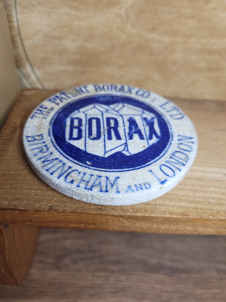 May include: A white ceramic lid with blue lettering that reads "The Patent Borax Co. Ltd Birmingham and London" and a blue logo that reads "Borax".