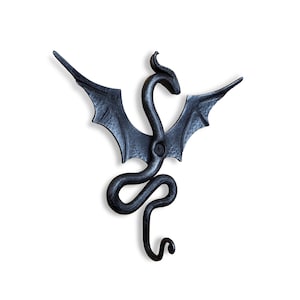 Puede incluir: Gancho de pared de metal negro en forma de dragón con las alas extendidas y la cola enroscada.
