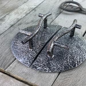 May include: A pair of black metal door handles with a rustic, branch-like design. The handles are mounted on round, textured plates.